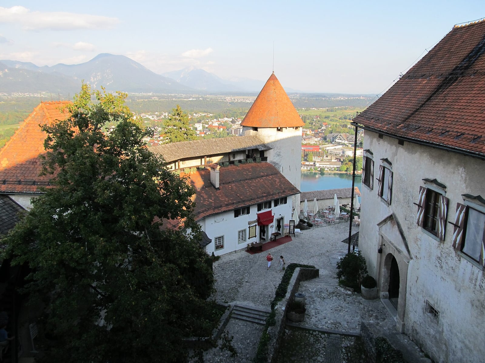 The lower courtyard of Bled Castle with stone buildings and red roofs