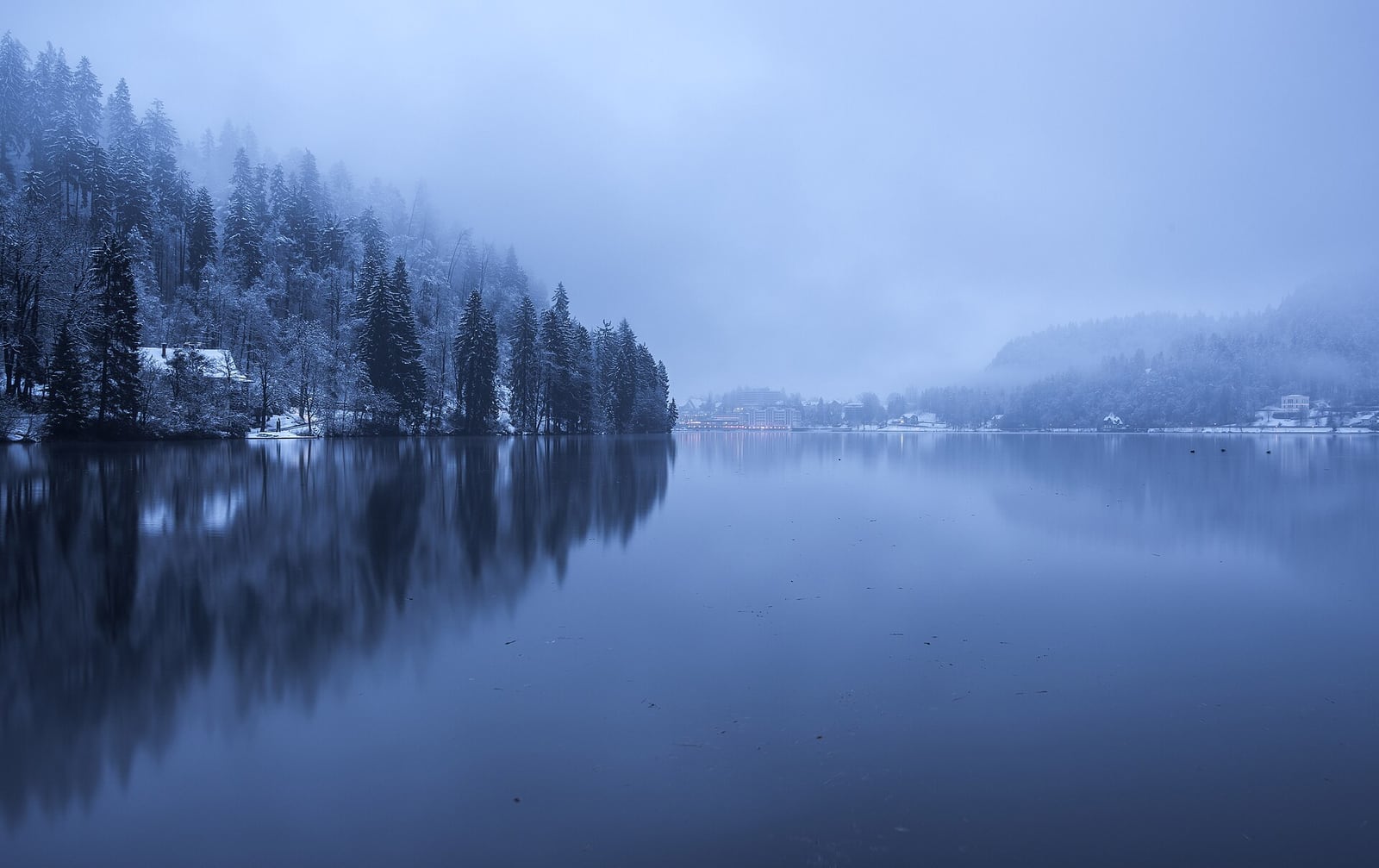A misty winter day on Lake Bled with snow along the shore